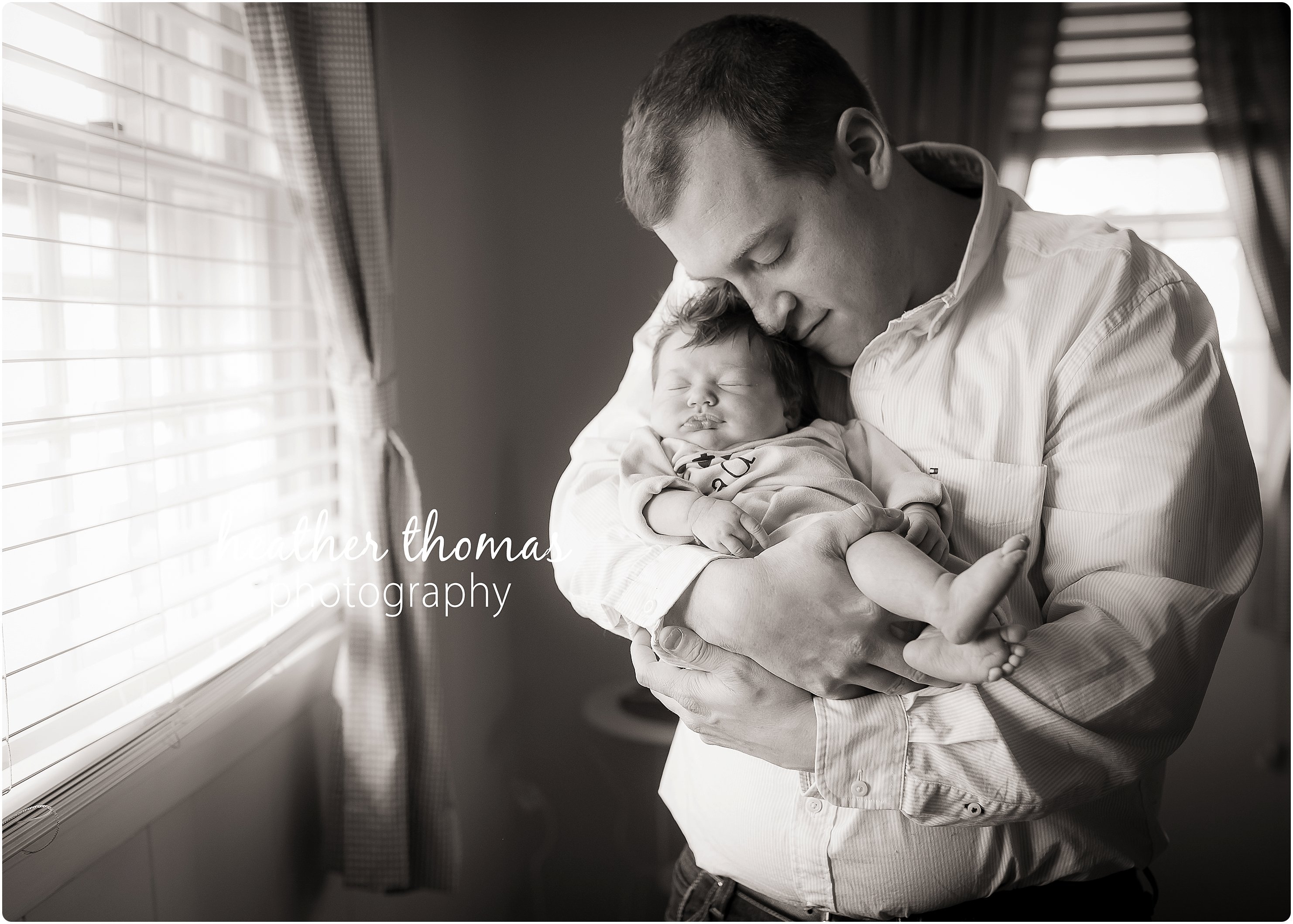 Yardley PA newborn photographer family of four with one newborn and one toddler cuddling and playing in their home in front of a big window in family room