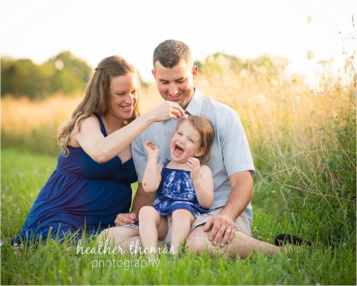 A family of three at a Maternity Photography in Philadelphia a family expecting a baby in a field during their Maternity Photography Philadelphia session