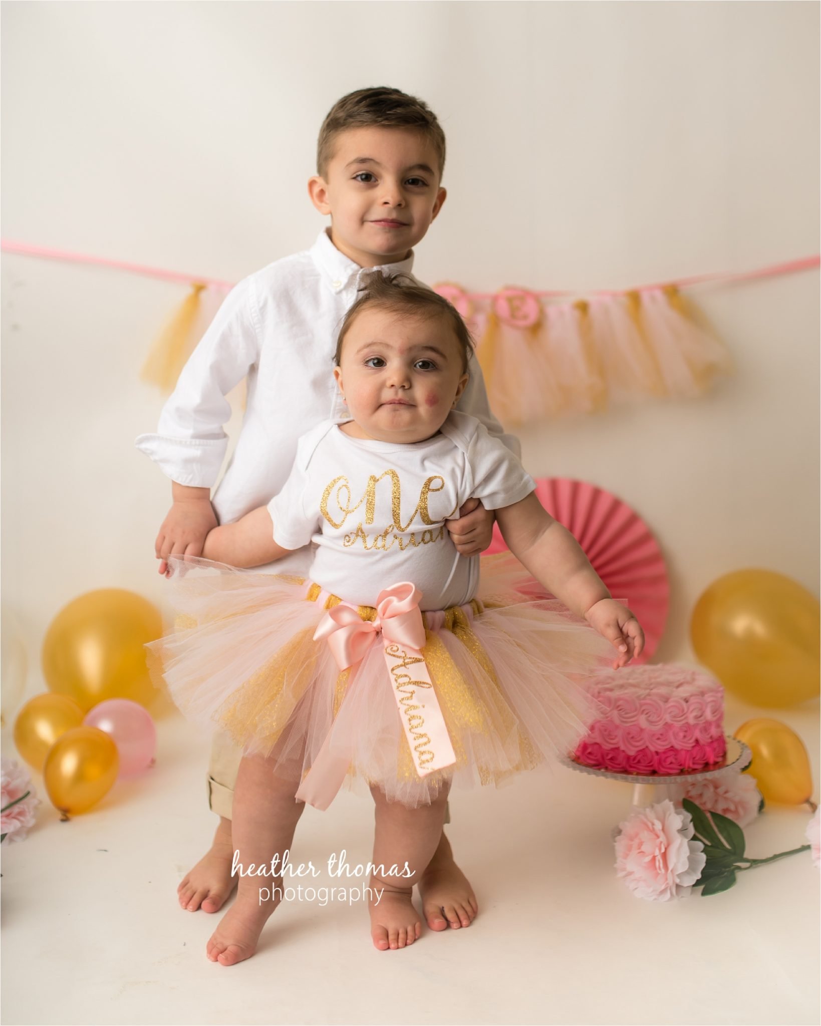 bucks county first birthday photographer-57.jpg a picture of a boy and girl holding hands for a photography shoot in newtown pa