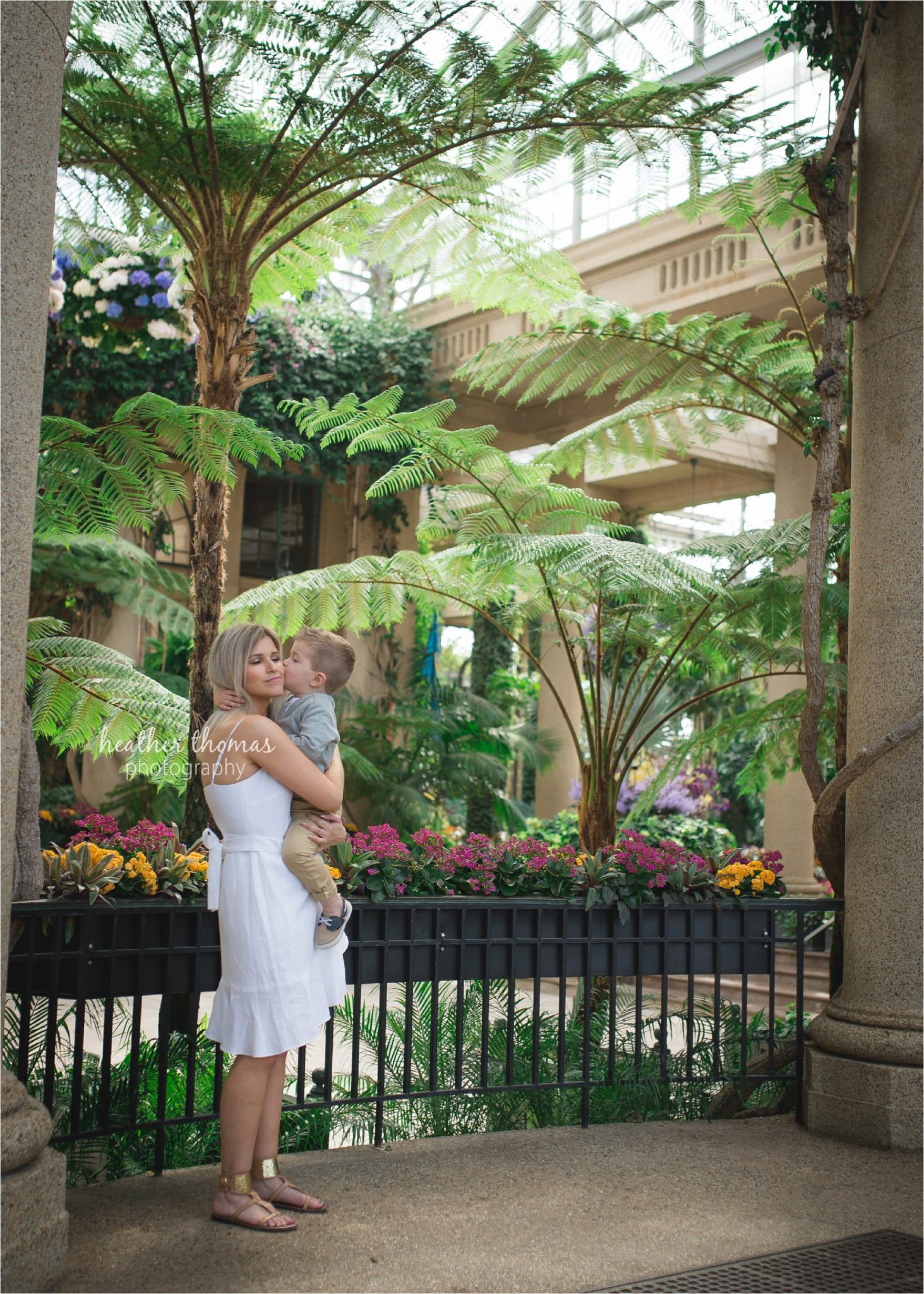 newtown pa family photographers-17.jpg a boy kissing his mom at longwood garden with heather thomas photography
