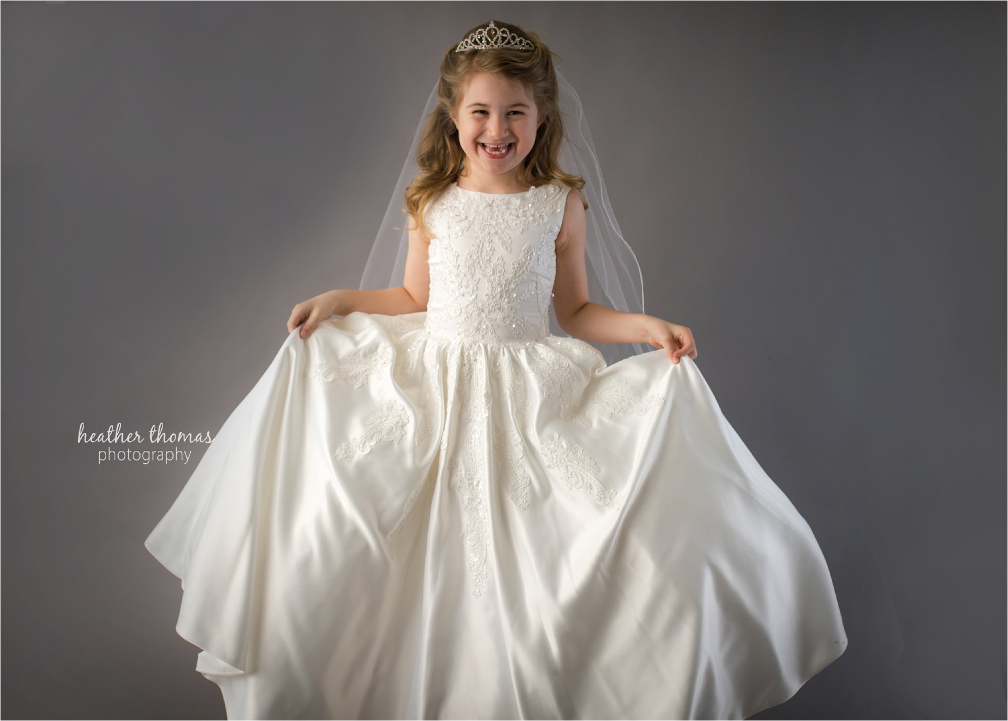 a portrait of a girl holding her communion dress at the photography studio in newtown maternity portraits of a family of three at azalea garden waterworks with heather thomas photography