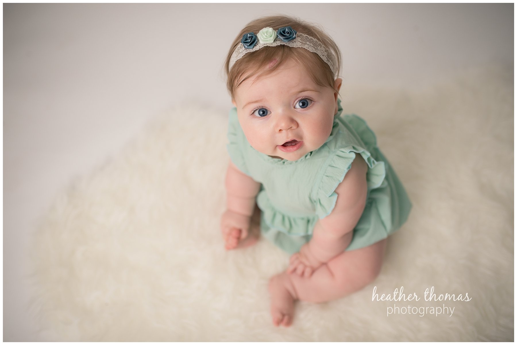 baby photo shoot philadelphia-2.jpg a portrait of a 7 month old sitting on a white rug looking up at the camera.