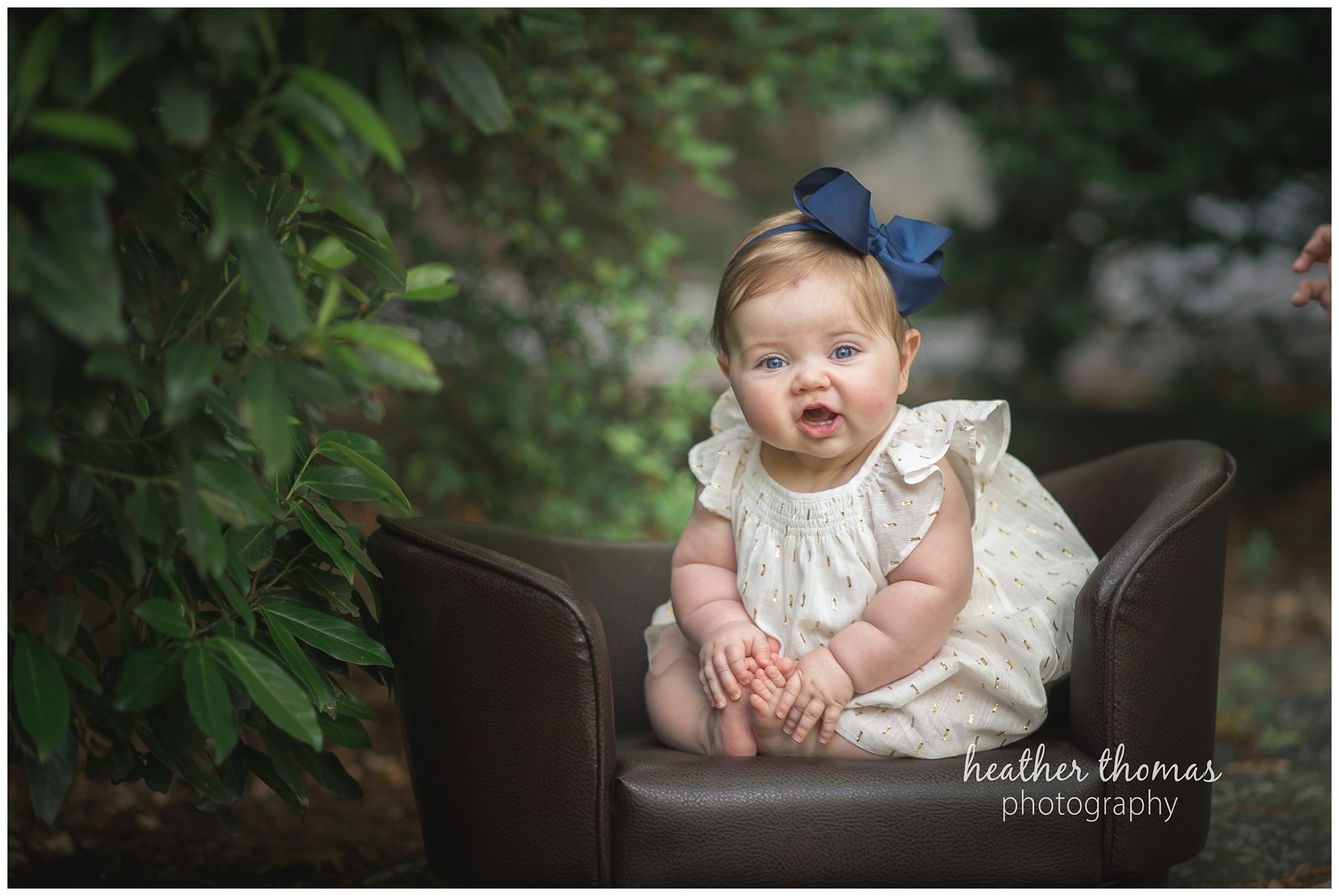 baby photo shoot philadelphia-41.jpg a 7 month old baby sitting outside in a brown chair for a photo shoot with heather thomas photography
