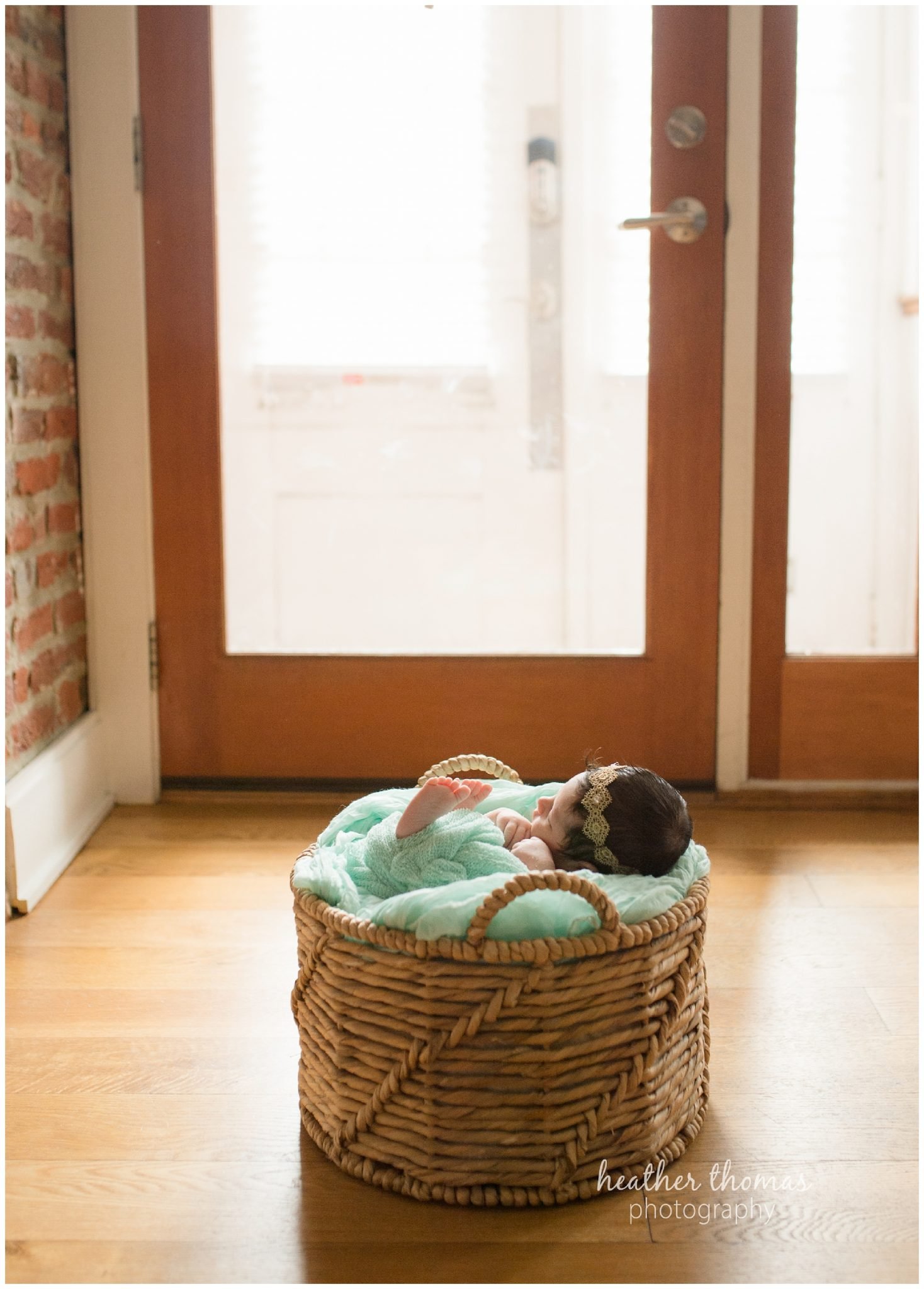 philadelphia lifestyle portraits-45.jpg a newborn baby girl wearing teal in a basket at a photo shoot in philadelphia with heather thomas photography