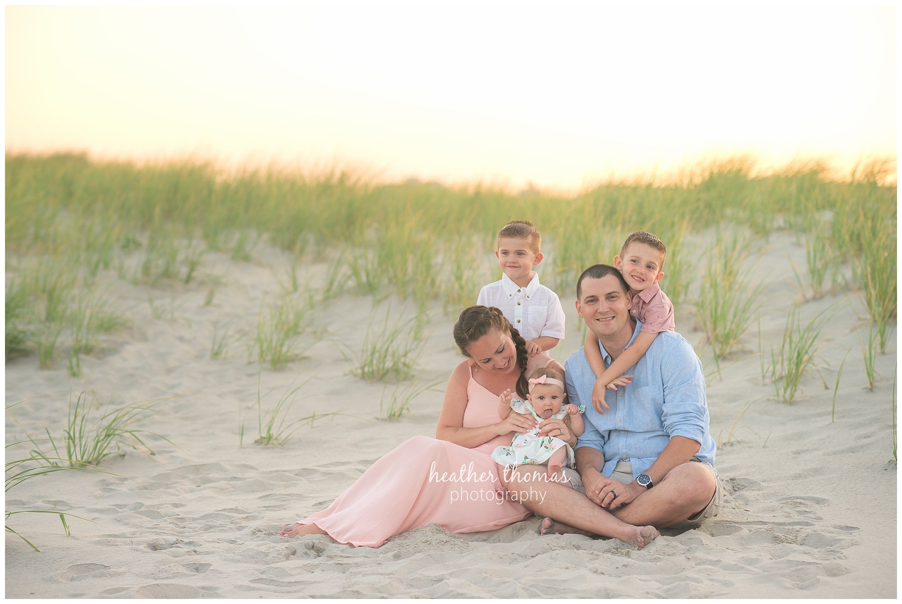 family beach photography ocnj-12.jpg a family with two boys and a baby girl laughing together on the beach in ocean city nj