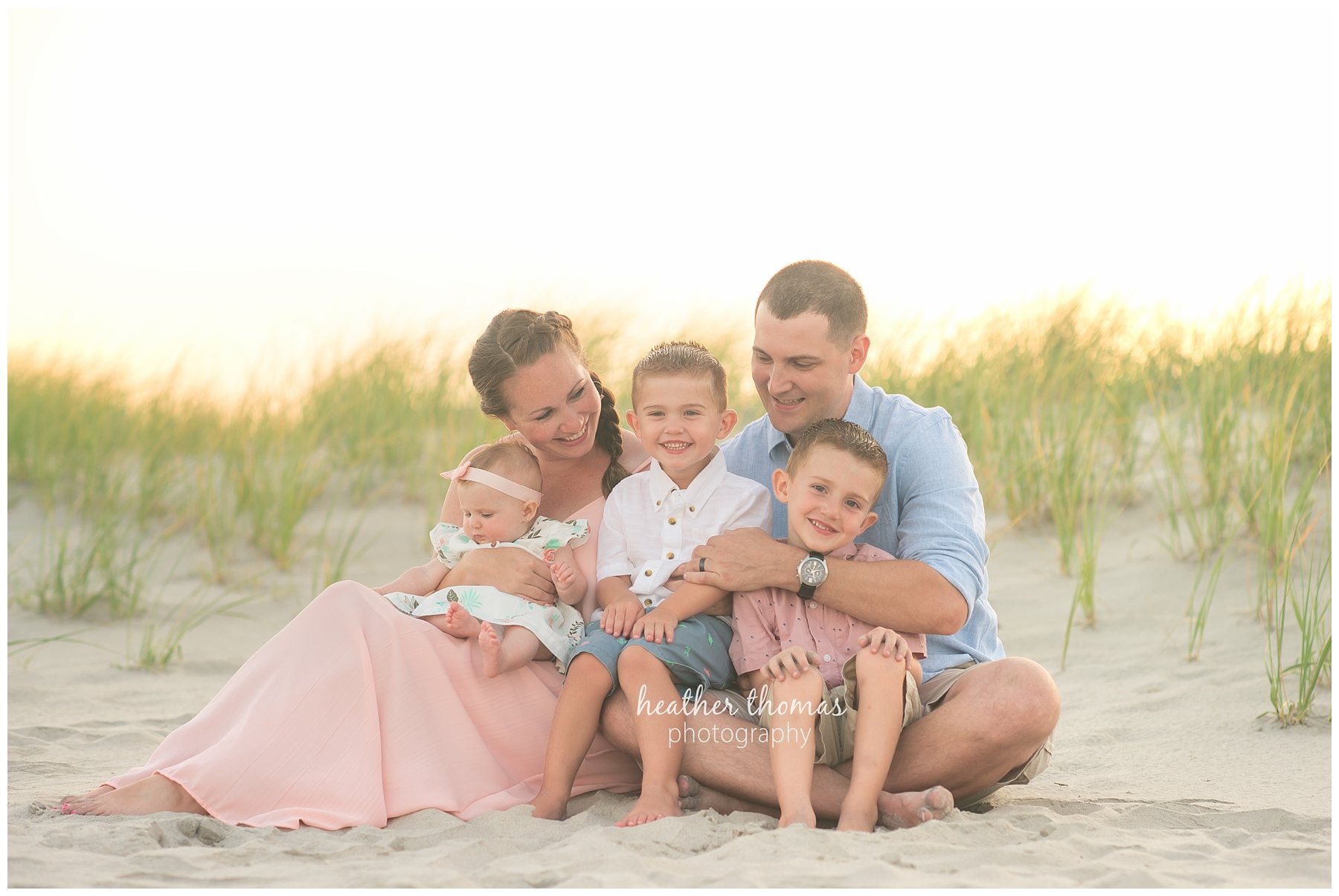 family beach photography ocnj-7.jpg a closeup of a family of 5 wearing pink white and blue on the dunes in ocean city NJ