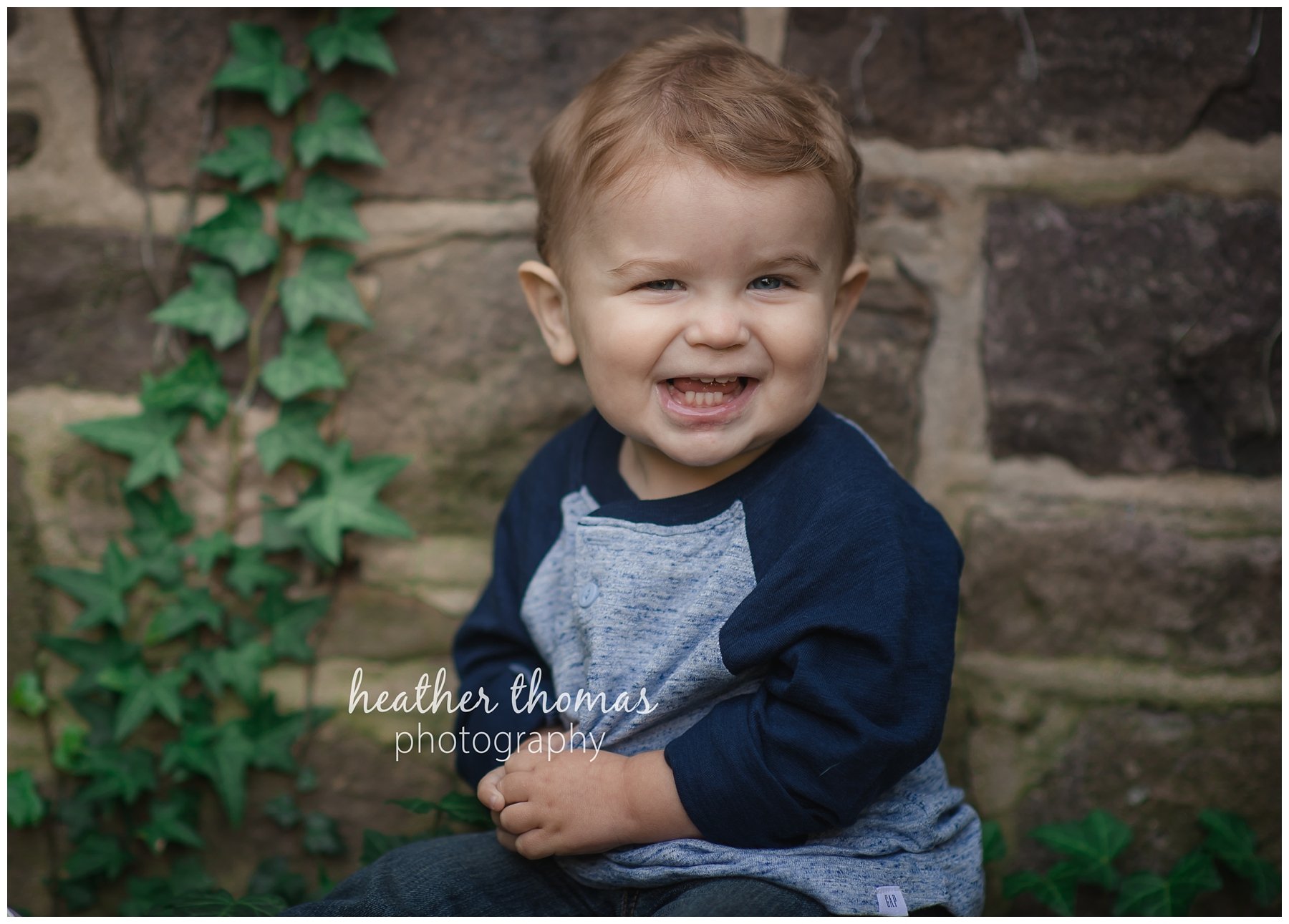 cake smash session in bucks county-13.jpg a one year old boy smiling at the camera in a blue shirt