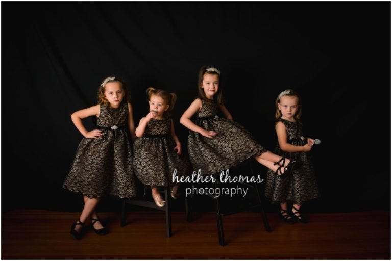 four cousin girls dressed in black at the heather thomas photography studio in newtown