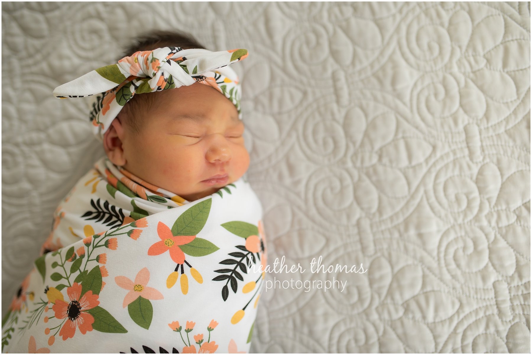 ricketti-newborn-photos-newtown-pa-1.jpg a newborn girl wrapped in a floral blanket laying on a bed during her photo shoot with heather thomas photography in newtown pa