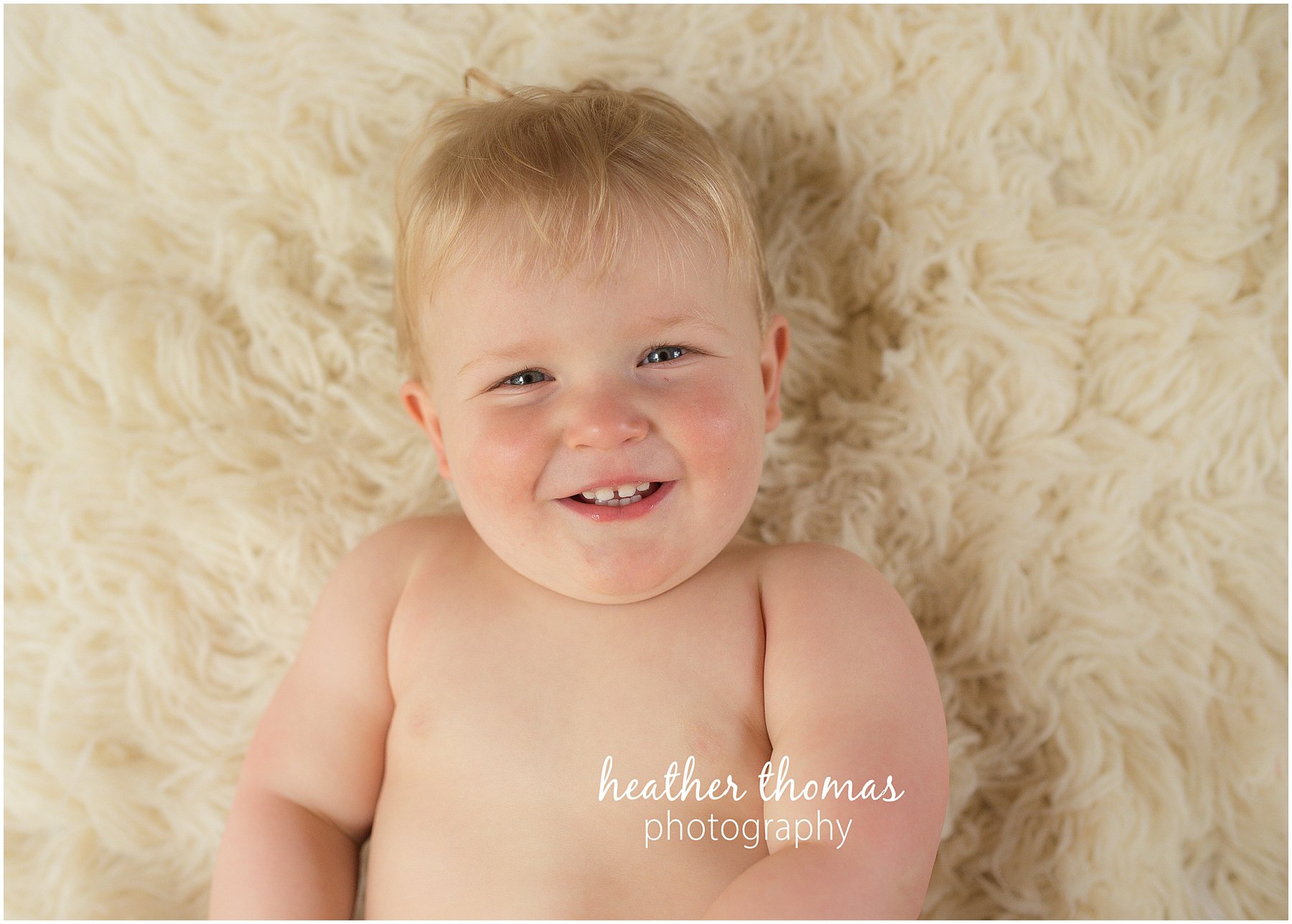 montgomery county family photographer-108.jpg a picture of a one year old boy laying on a white rug