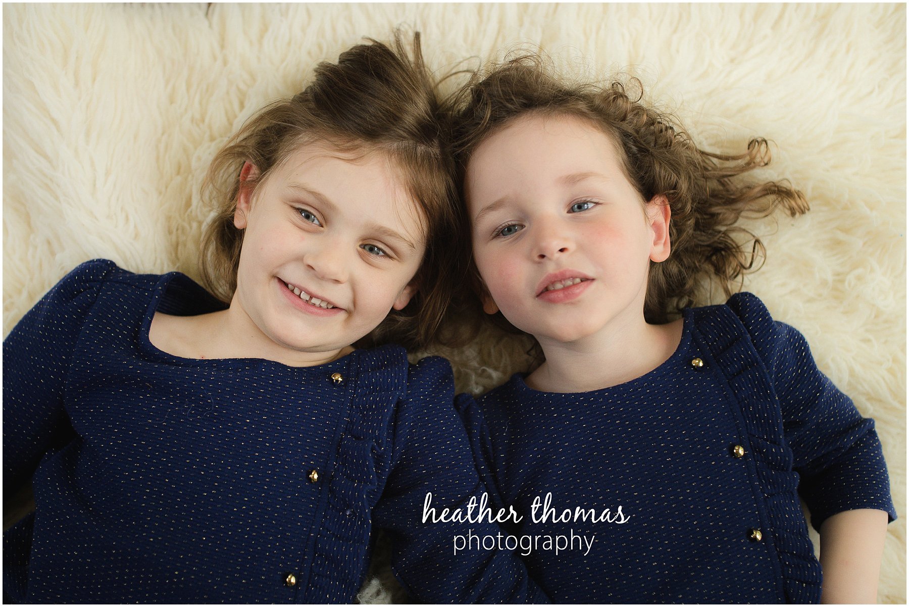 montgomery county family photographer-89.jpg a picture of two girls laying on a white rug in lansdale pa for a lifestyle portrait session