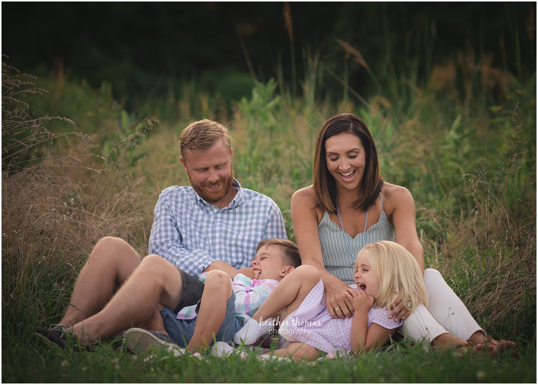 Fjellman Family Portraits-19.jpg a picture of a family tickling eachother at a field during a photo shoot with heather thomas photography