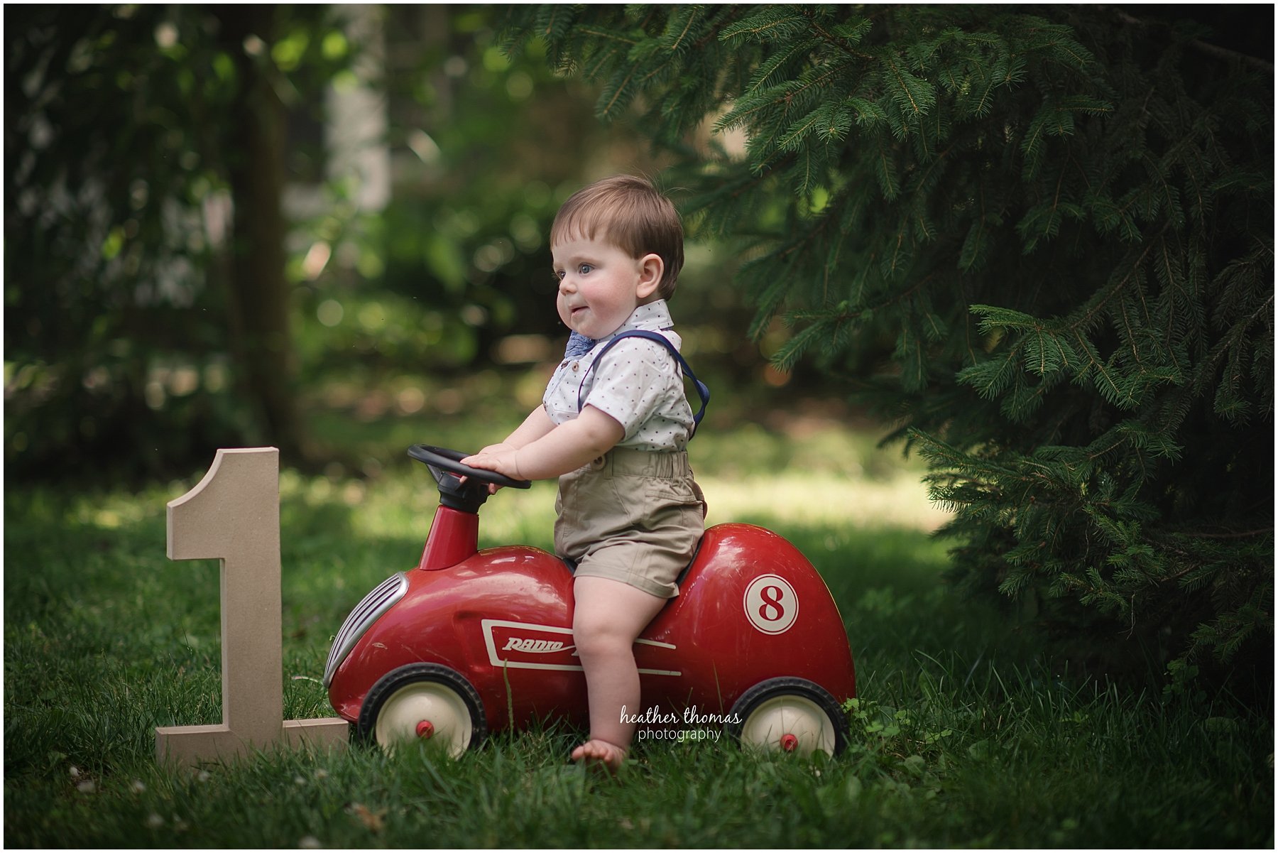 first birthday photos philadelphia-32.jpg a picture of a one year boy on a radio flyer bike outside
