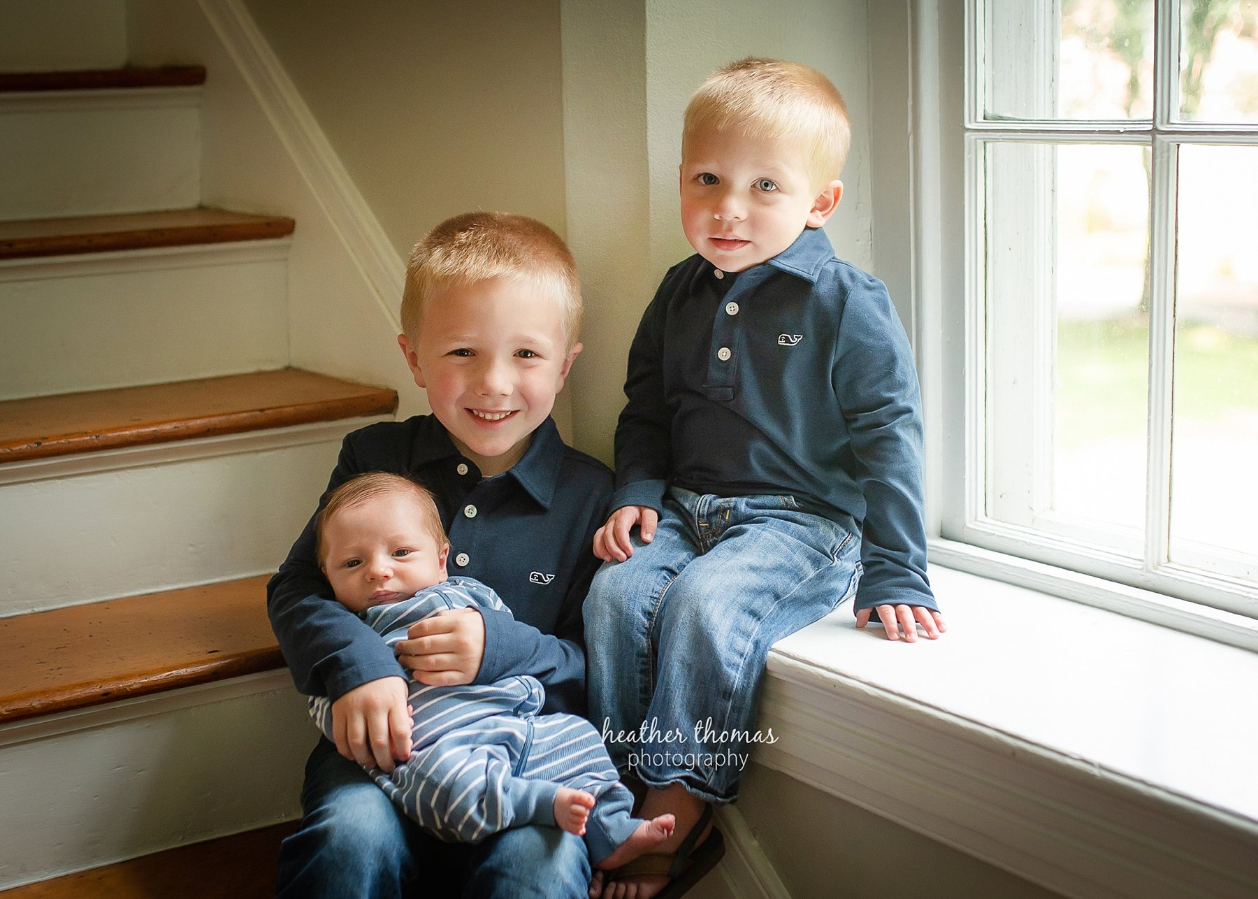 newborn portraits in bucks county pa a picture of three boys sitting on the stairs at the heather thomas photography studio in Newtown bucks county pa
