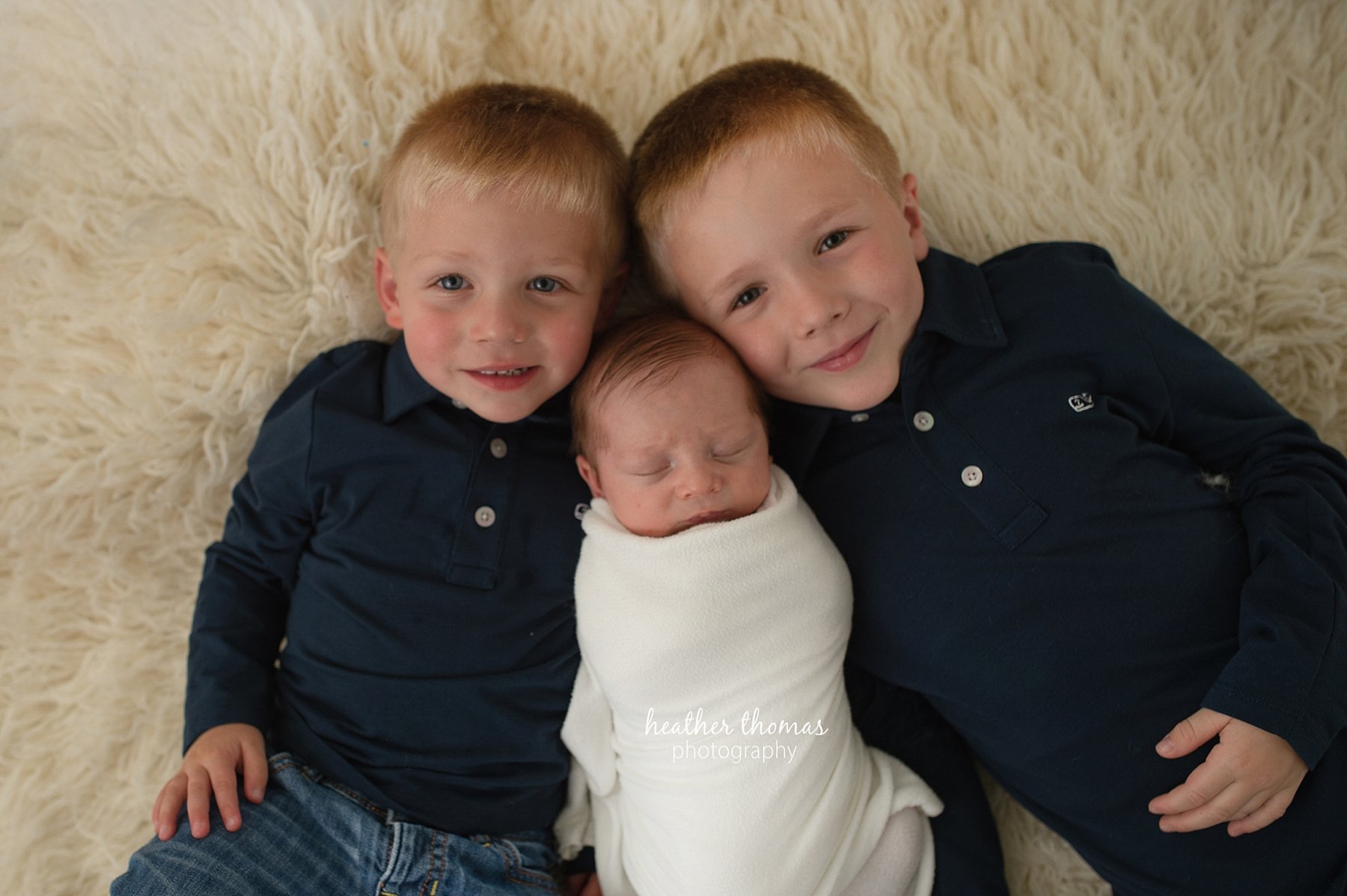 newborn portraits in bucks county pa three boys laying on a rug for a photo shoot with heather thomas photography