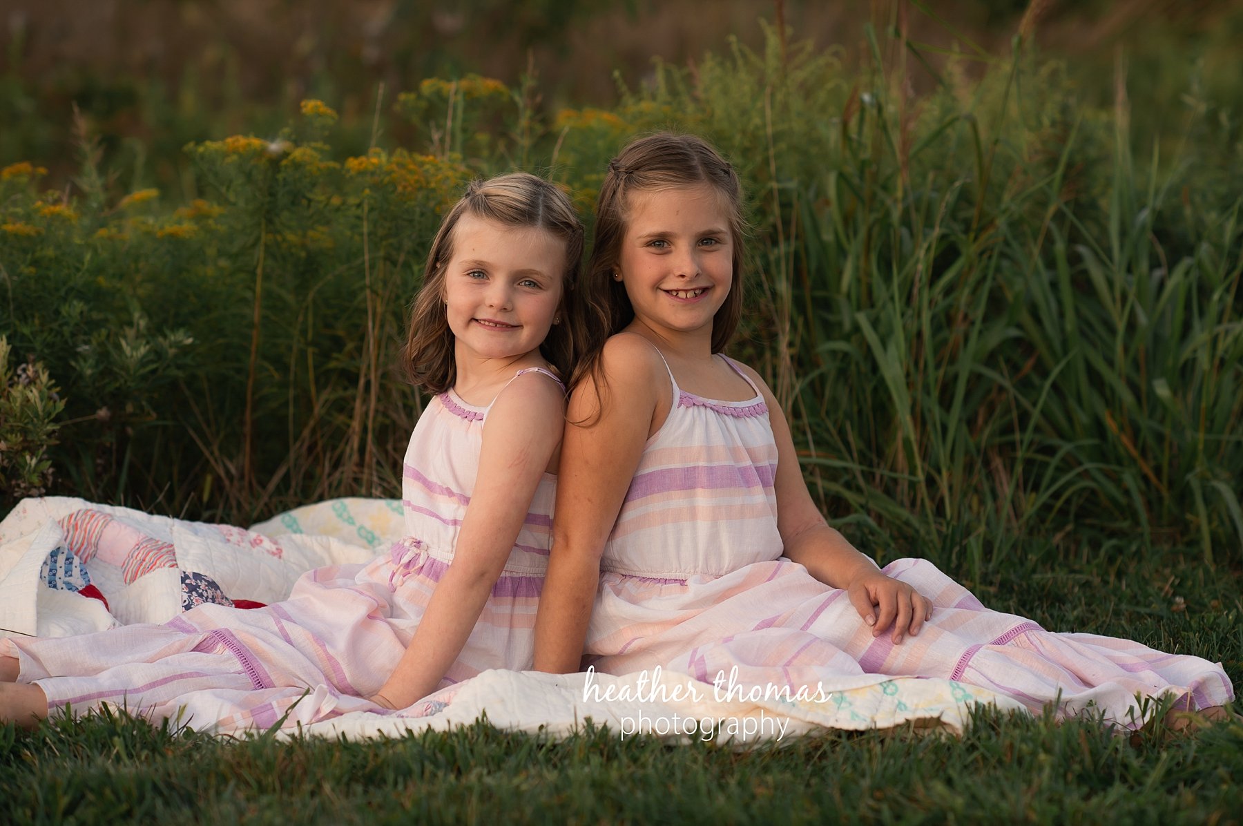 field family portraits in philadelphia a picture of two girls sitting on a blanket in the grass