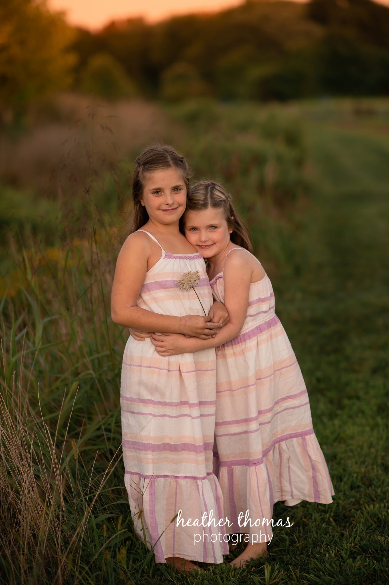 field family portraits in philadelphia a picture of two girls leaning on each other in a field in bucks county