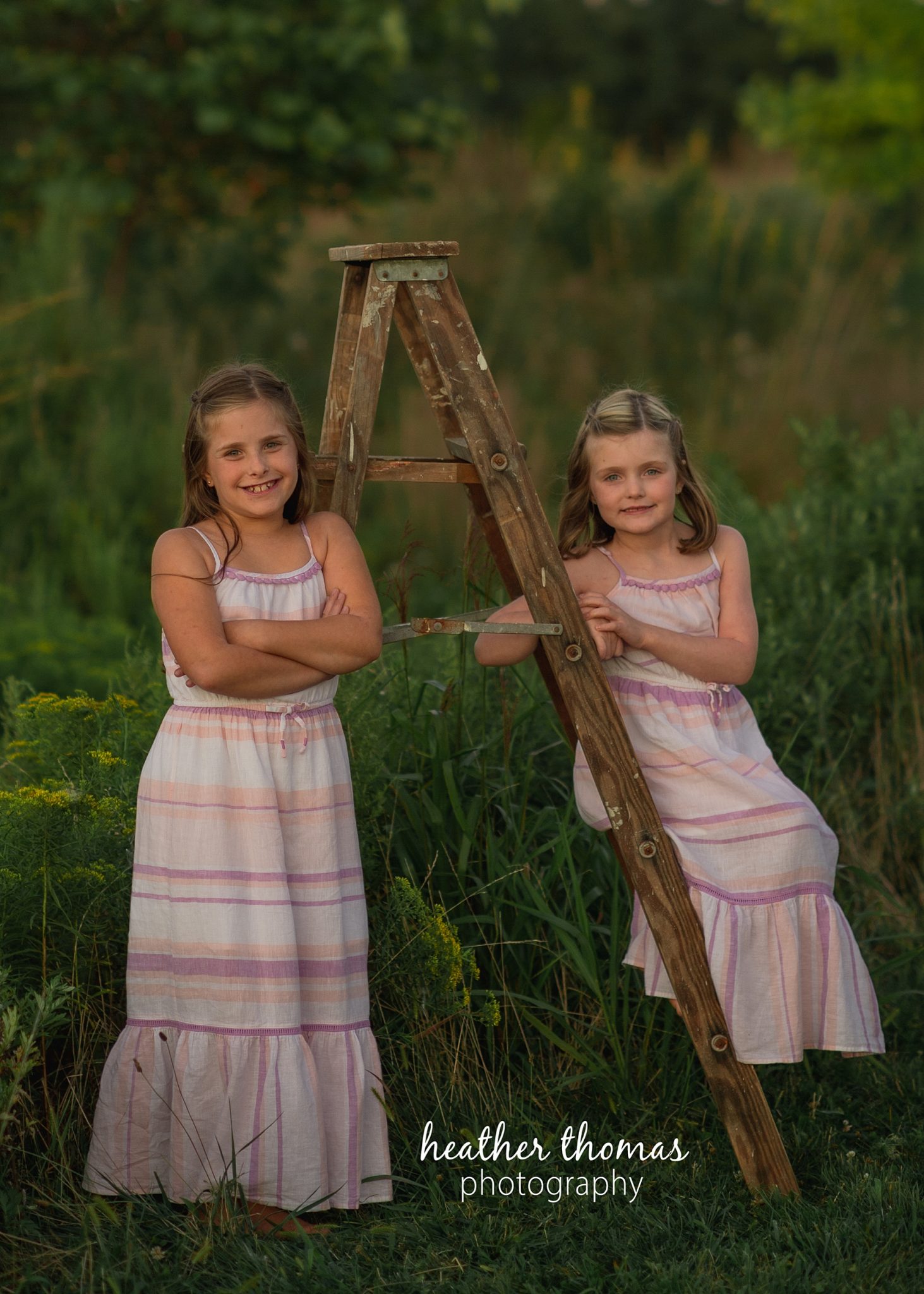 field family portraits in philadelphia a picture of two girls on a ladder in a field for a photo shoot with heather thomas photography philadelphia