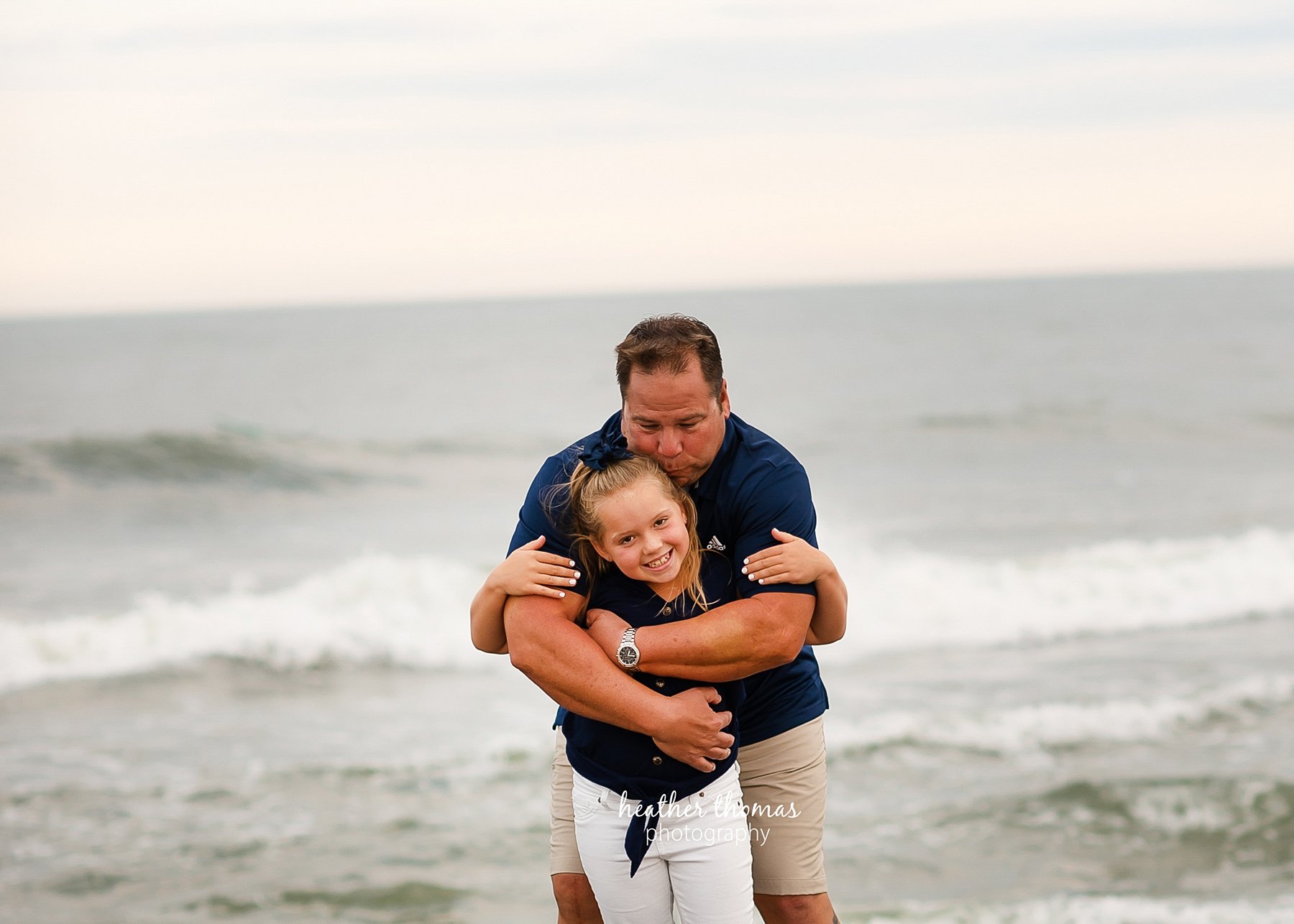 a family photo shoot in ocean city nj a dad kissing his daughter on the beach in ocean city nj