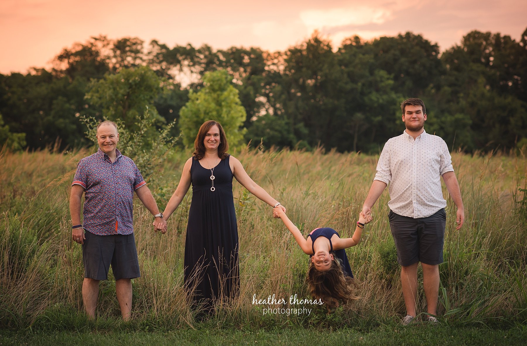 field family portraits in philadelphia a picture of a family posing outside in a field in philadelphia with heather thomas photography