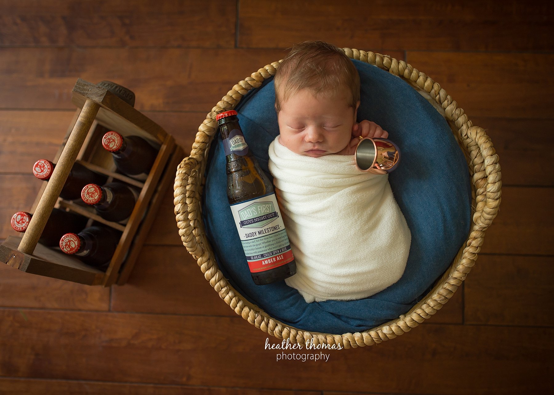 a newborn in home photo shoot in bucks county a picture of a baby in a basket with beer