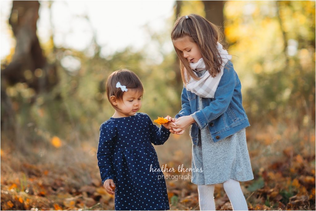 Making Memories at Home | Bucks County, PA Family Photographer portrait of two sisters playing in fall leaves