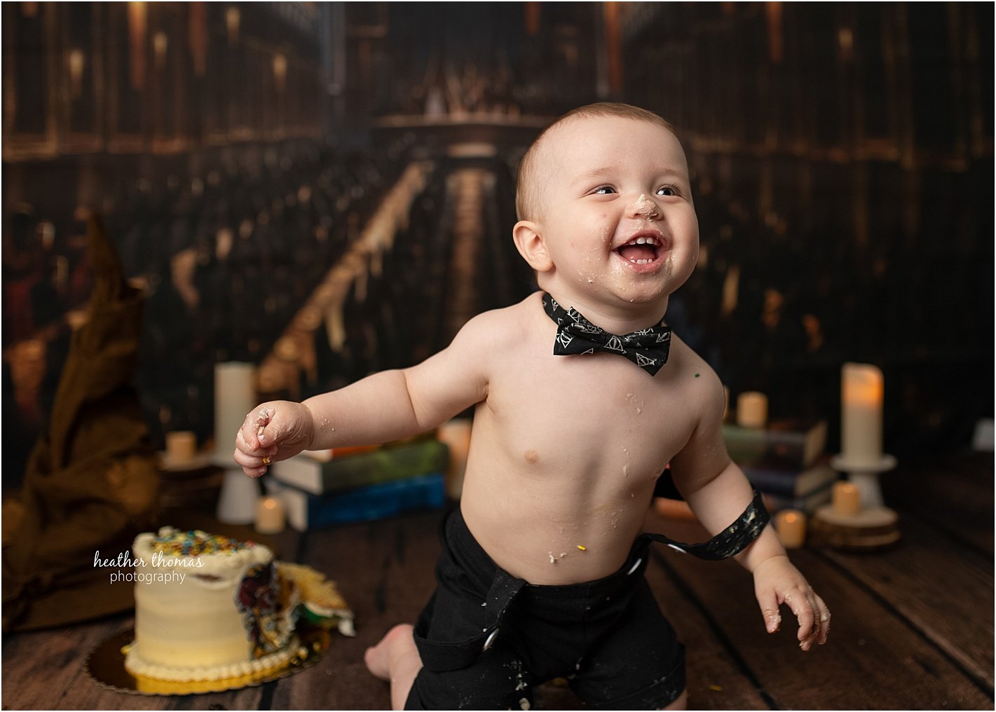 Cake Smash Photography in Philadelphia, PA First birthday cake smash celebration featuring Harry Potter theme with adorable boy and loving parents at Philadelphia photography studio