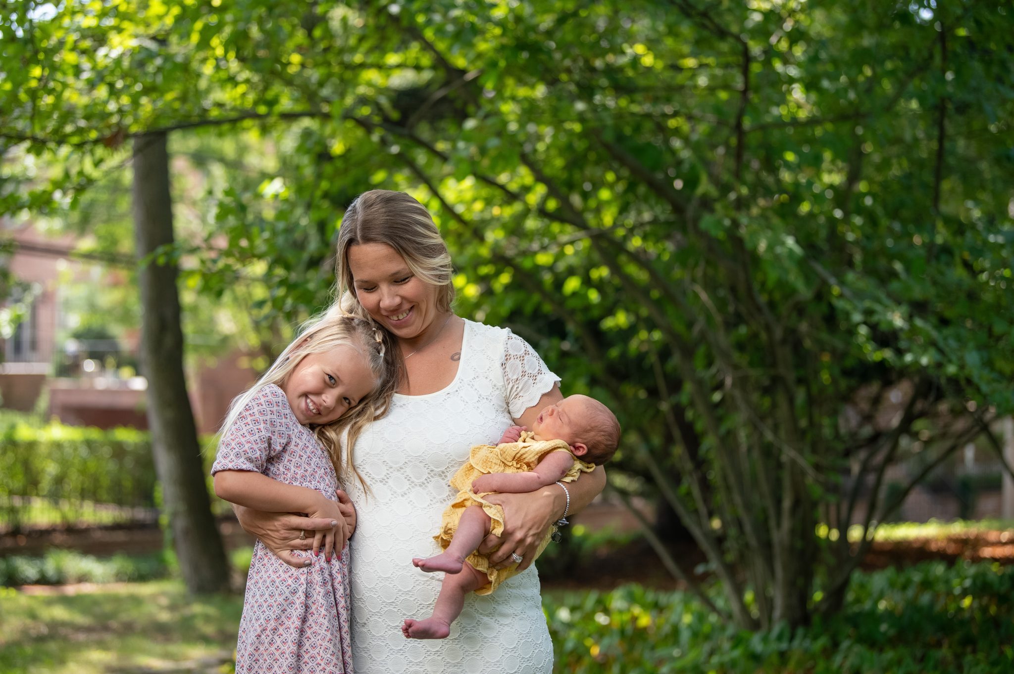 Philadelphia Newborn Photographer a mother hugging her two children at a newborn photo shoot with heather thomas photography