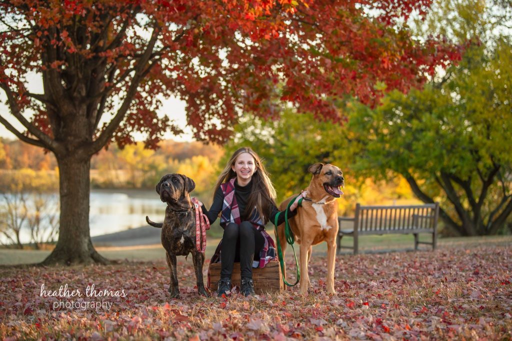 Fall Mini Session Photography in Philadelphia Philadelphia photography session captures confident young client with pet among autumn trees