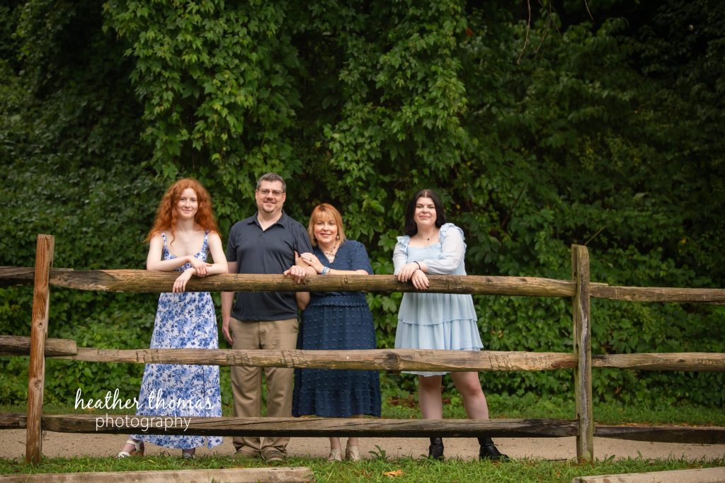 a family of 4 at their photo shoot with bucks county family photographer heather thomas-004 a family on a fence at a photo shoot in bucks county pa