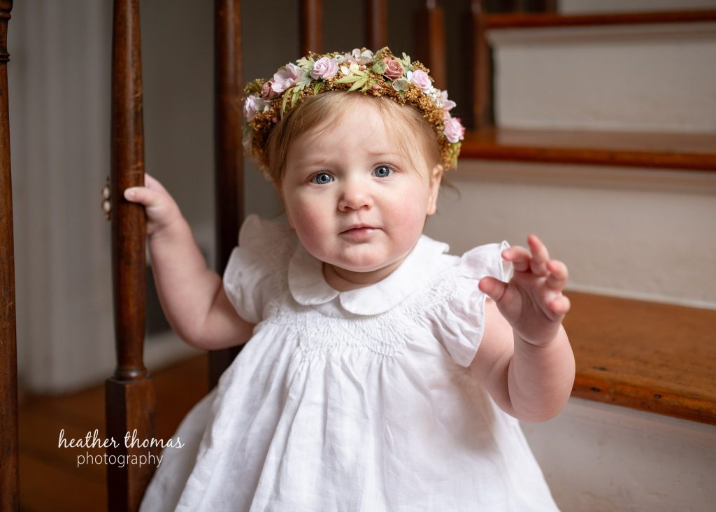 5 Things To#15 Ask Before Your Cake Smash Shoot | Bucks County Family Photographer little one wearing floral crown on stairs by Bucks County Family Photographer