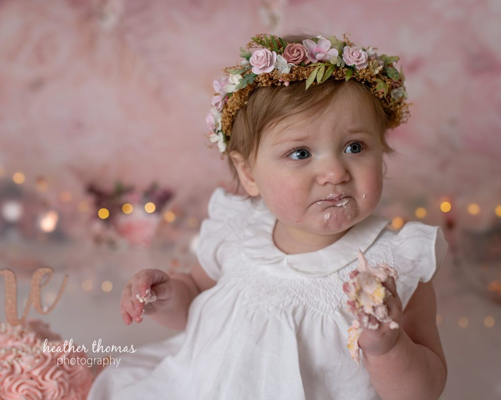 5 Things To#15 Ask Before Your Cake Smash Shoot | Bucks County Family Photographer infant eats frosting in pink studio by Heather Thomas Photography