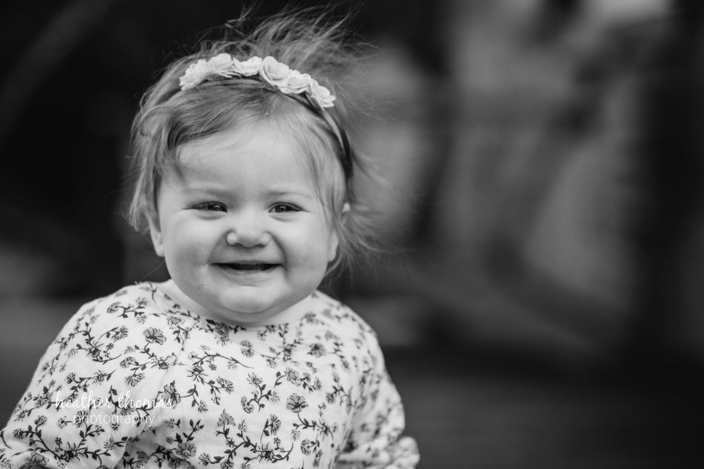 5 Things To#15 Ask Before Your Cake Smash Shoot | Bucks County Family Photographer little girl smiles outdoors before learning 5 Things To Ask Before Your Cake Smash Shoot
