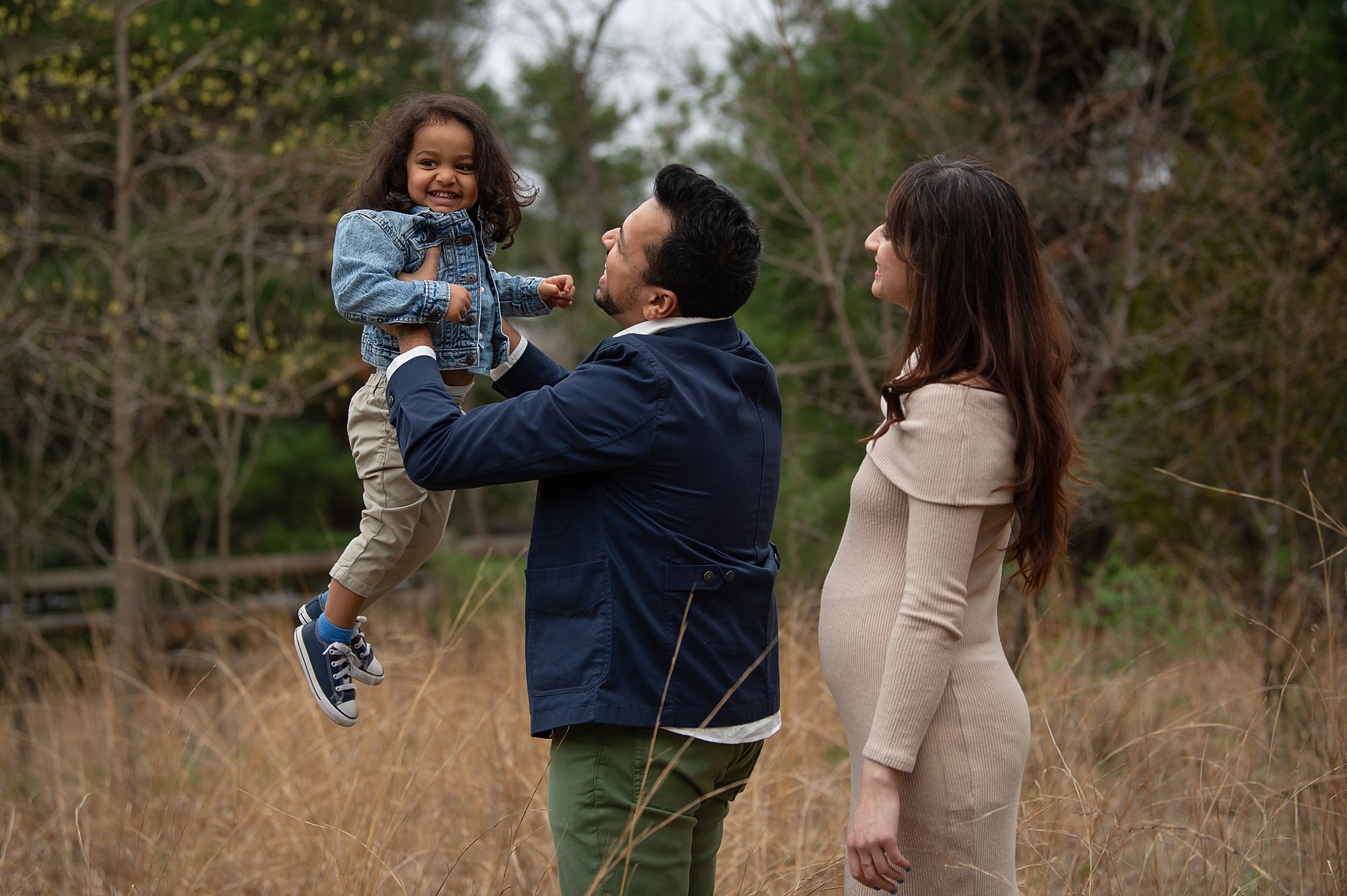 Siriwardana - Family-12_south-jersey-family-photos-with-heather-thomas-photography.jpg a family lifting their toddler up enjoying a photo session in a beautiful meadow field at boundary creek park, showcasing one of the 7 stunning South Jersey photo locations near Philadelphia